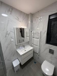 a white bathroom with a sink and a toilet at Adria Flow Apartments in Meljine +12 photos