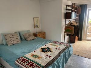 a bedroom with a bed with a blanket on it at Casa da Nespereira in Aljezur