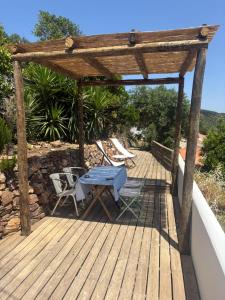 a wooden deck with a table and chairs on it at Casa da Nespereira in Aljezur