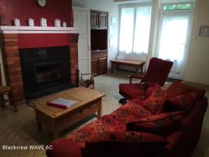a living room with a couch and a fireplace at Cottage by the Chateau with pool in National Parc in Les Salles-Lavauguyon