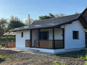 a small white house with a black roof at Hill's Peak in Cacica