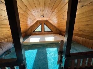 a small room with a bed in a wooden cabin at Hill's Peak in Cacica