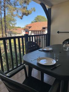 a table on a balcony with a plate on it at Superbe appartement 6 personnes in Biscarrosse