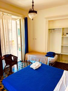 a bedroom with two beds and a blue bedspread at Sedile Dei Nobili Apartment in Tropea