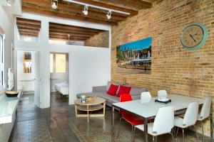 sala de estar con pared de ladrillo, mesa y sillas en Happy People Plaza España Apartments, en Barcelona