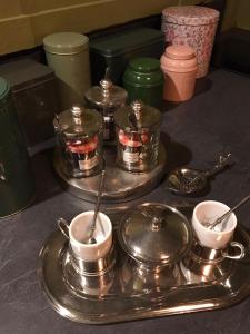 a group of silver dishes and cups on a counter at A Vol D'Oiseau in Honfleur