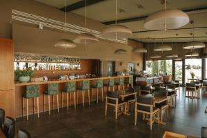 a restaurant with tables and chairs and a bar at Herdade da Cortesia Hotel in Avis