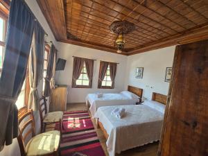 a bedroom with two beds and a ceiling with windows at Guest House J.Prifti in Berat