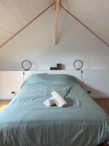 a bedroom with a green bed with two towels on it at Gulf Stone in Séné +8 photos