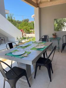 a table and chairs on a patio with a table and chairs at Rose garden home in Metaxáta
