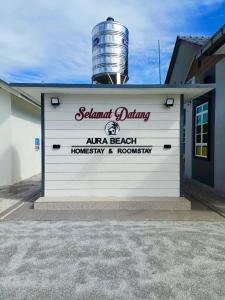 a white building with a brewery sign on it at Aura Beach Homestay in Kampong Ru Sepuloh