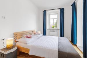 a bedroom with a bed with blue curtains and a window at Sponge Apartmá - Resort Abertham in Abertamy