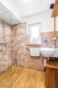 a bathroom with a sink and a glass shower at Sponge Apartmá - Resort Abertham in Abertamy