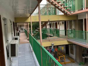 an empty hallway of a building with green railing at hotel mexico in Mexicali