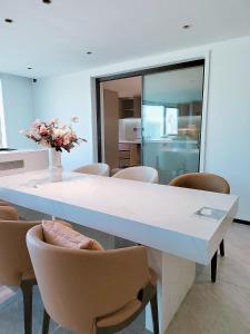 a dining room with a white table and chairs at Shanghai Skyline - Spacious&Elegant Luxury Apartment in Lujiazui near Shanghai Center Tower in Shanghai
