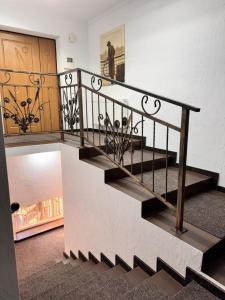 a staircase in a house with a wooden door at Small House ApartHotel in Chişinău