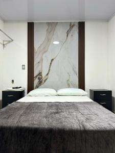 a bedroom with a large bed with a marble wall at Hotel Brisas Del Mar Suite in Santa Marta