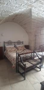 ein Schlafzimmer mit einem Bett und einer Steinwand in der Unterkunft alaséu in Bitonto