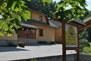 a sign in front of a building with a house at Ubytovňa Priehrada in Trstená