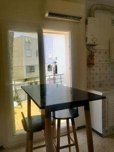 een keuken met een tafel en 2 stoelen en een raam bij american terrace sousse centre in Sousse +10 foto's