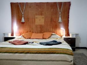een slaapkamer met een groot bed met een houten hoofdeinde bij american terrace sousse centre in Sousse