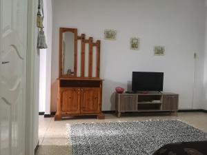 een woonkamer met een televisie en een spiegel bij american terrace sousse centre in Sousse
