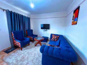 a living room with a blue couch and two chairs at Lakeside Two Bedroom Penthouses in Goat Island