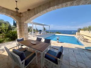 a patio with a table and chairs and a swimming pool at Casa Oliva Villa A with heating pool in Budva