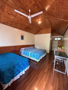 a bedroom with two beds and a ceiling fan at Hare Village in Hanga Roa +14 photos