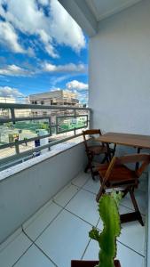 a balcony with a table and chairs and a view of the beach at Apartamento em Vitoria da Conquista in Vitória da Conquista