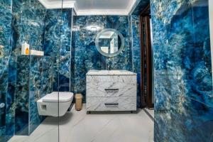 baño con paredes azules, aseo y espejo en Răsărit la Mare, en Constanţa 148 fotos más
