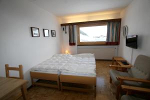 a bedroom with a bed and a table and a window at Studio Résidence Rosablanche Siviez in Siviez