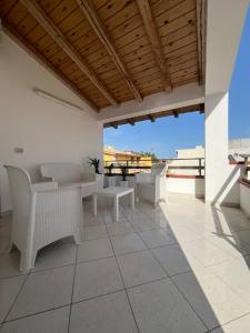 patio con mobili bianchi e vista sull'oceano di Casa Don Ciccio a Donnalucata