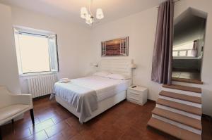 a bedroom with a white bed and a staircase at Maiano Relais in Suio