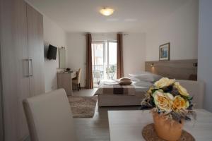 a bedroom with a bed and a table with a vase of flowers at Apartments Bota in Drvenik