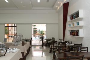 a dining room with tables and chairs and a large window at Hotel Solar Rio de Pedras in Luis Eduardo Magalhaes