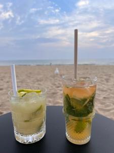 two drinks sitting on a table at the beach at Villa en bord de mer 6 personnes, à côte du Château des Tourelles, piscine d'eau de mer in Pornichet