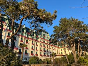 a large white building with red and green windows at Villa en bord de mer 6 personnes, à côte du Château des Tourelles, piscine d'eau de mer in Pornichet