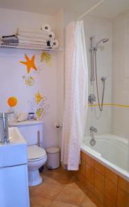a bathroom with a toilet and a tub and a sink at Suite-appartement 2 chambres à la campagne. Rez de jardin in Dunham