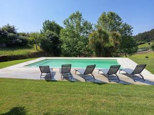 a group of chairs sitting in front of a swimming pool at Casas das Japoneiras in Paredes de Coura