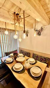 a wooden table with plates on it in a dining room at La Tana del Cervo del Maso K in Folgaria