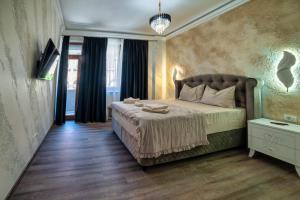 Un dormitorio con una cama y una lámpara de araña en Răsărit la Mare, en Constanţa