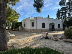 a white building with a tree in front of it at Villa Oronzo in Torre Lapillo