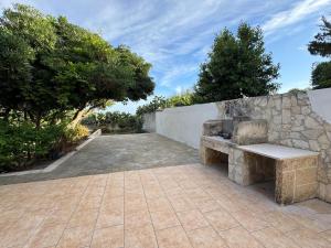a stone bench sitting next to a stone wall at Villa Oronzo in Torre Lapillo +10 photos