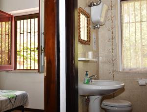 two pictures of a bathroom with a sink and a toilet at Villa Bellevue in Santa Maria +18 photos