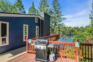a barbecue on the deck of a tiny house at Exclusive Lakefront For 10 with Sauna Kayaks Peace in Snohomish +27 photos