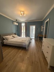 a bedroom with a bed and a wooden floor at Chernomorets Apartment in Chernomorets