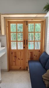 ブラジリアにあるTinyHouse das Ararasの窓付きの木製のドアのあるリビングルーム