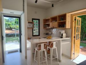 a kitchen with a counter and two stools at Tiny House das Araras in Brasília