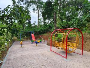 a playground with colorful play equipment in a park at Himadri Retreat Wayanad in Kaniyāmbetta